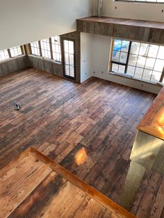 an empty room with wooden floors and windows