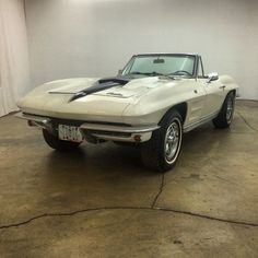 a white car parked in a garage next to a wall