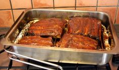 some ribs are cooking in a pan on the stove