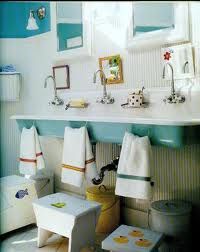 a bathroom with blue and white walls, two sinks and towels hanging on the wall