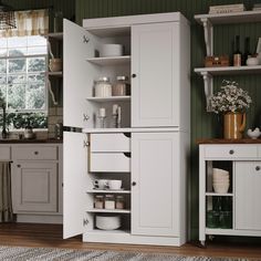 a kitchen with white cabinets and wooden floors