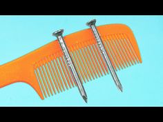 two orange combs with metal blades on top of each other against a blue background