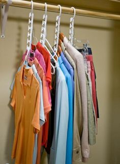 several shirts hanging on a rail in a closet