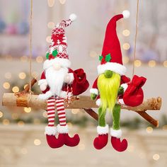 two elf ornaments hanging from a tree branch