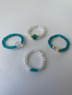 three bracelets with pearls and beads on a white surface, one is blue the other is white