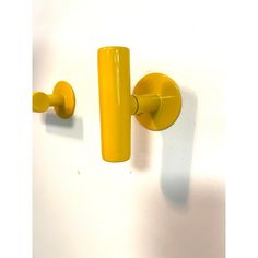 a yellow door handle on a white wall