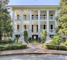 a large white house with many balconies on it's front porchs