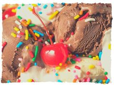 an ice cream sundae with sprinkles, cherries and chocolate frosting