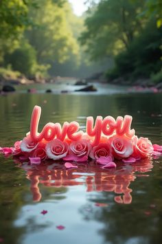 the word love you spelled out with roses in front of a river filled with water