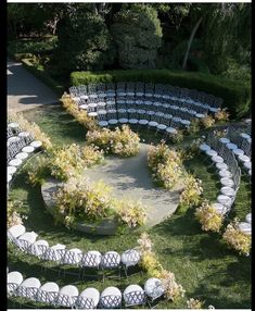 an aerial view of a circular seating arrangement with white chairs and greenery in the center