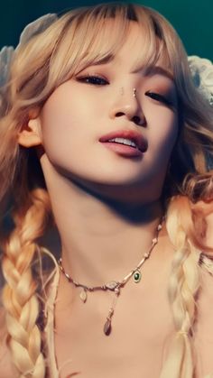 a woman with long blonde hair wearing a white dress and necklace on her neck is posing for the camera