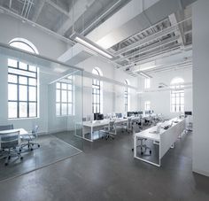 an empty office with desks and chairs in the middle of it, along with large windows