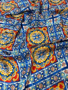 an intricately designed blue and red cloth with circular designs on it's sides