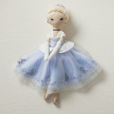 a doll is wearing a blue and white dress