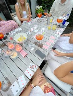 people sitting around a table with cards on it