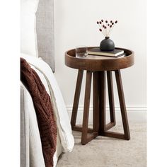 a small wooden table sitting on top of a bed