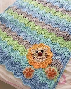 there is a crocheted blanket with a lion on it and paw prints in the middle