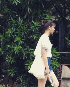 a woman is walking down the street with an umbrella