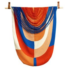 an orange and blue scarf hanging on a wall