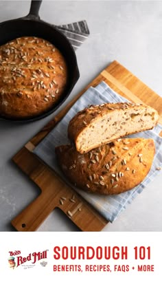 a loaf of bread sitting on top of a cutting board next to a skillet