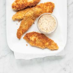 fried fish sticks with dipping sauce on a white plate