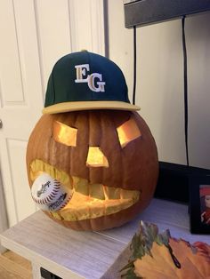 a baseball cap on top of a carved pumpkin