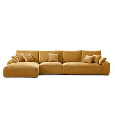 a large sectional couch with pillows on the top and bottom corner, in mustard colored fabric