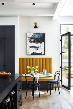 a dining room with black and yellow chairs