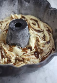 a cake in a metal pan with icing swirled around the edges and inside it