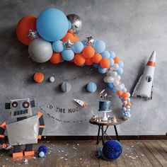 a room decorated with balloons and decorations for an astronaut themed birthday or baby's first birthday