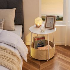 a bed room with a neatly made bed and a night stand next to the window