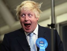 a man in a suit and tie with a blue ribbon around his neck, making a surprised face