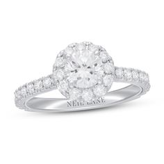 a white gold engagement ring with diamonds on the band and an oval center stone surrounded by round