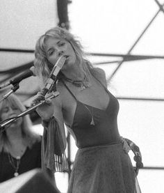 a woman singing into a microphone on stage