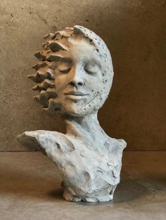 a sculpture of a woman's head with her eyes closed