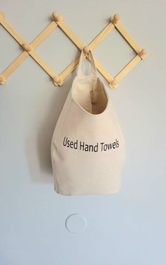 a white bag hanging on a wall with the words used hand towels printed on it