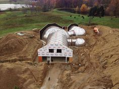 an aerial view of a house under construction in the fall with trees and grass around it