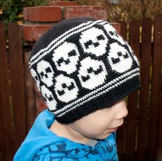 a young boy wearing a knitted hat with skulls on it