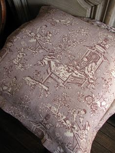 two pillows sitting next to each other on top of a wooden floor in front of a window