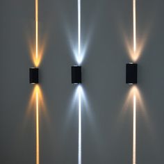 three lights that are on the side of a wall