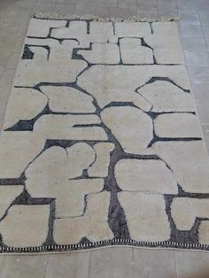 an area rug with various shapes and sizes on the floor in a room that has tile floors