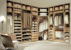 an open closet with clothes and shoes in it