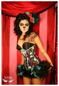 a woman wearing a costume with skulls on her face and hair in the shape of a corset