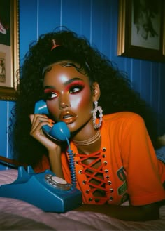 a woman laying in bed talking on a phone and holding a telephone to her ear