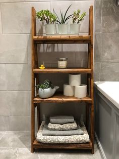 a wooden shelf filled with towels and plants