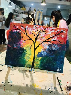 two women are painting in an art class