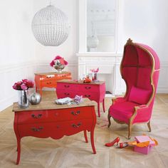 a living room filled with furniture and flowers on top of a wooden floor next to a white wall