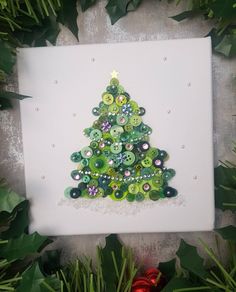 a christmas tree made out of buttons on a canvas