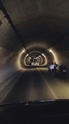 some people are walking through a tunnel with the word run on it's side