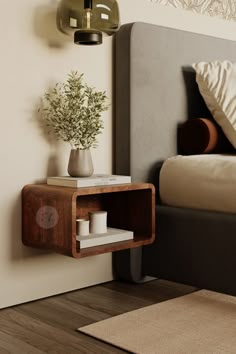 a bed room with a neatly made bed and a small plant on the side table